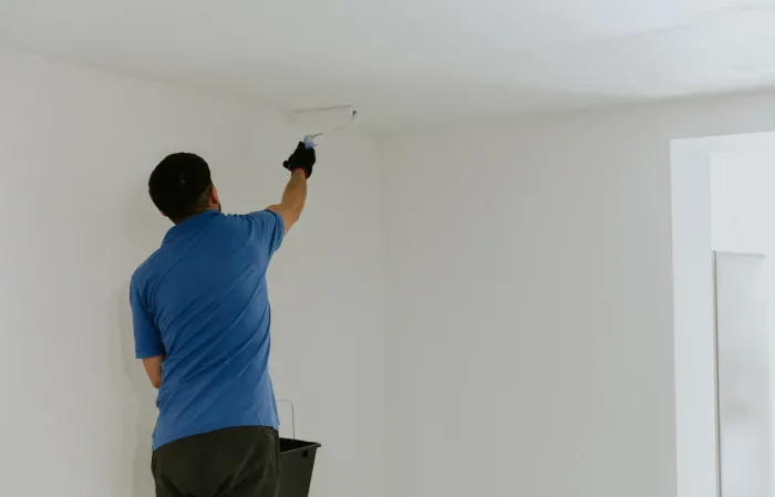 Un peintre applique un revêtement mural au plafond à Bouliac